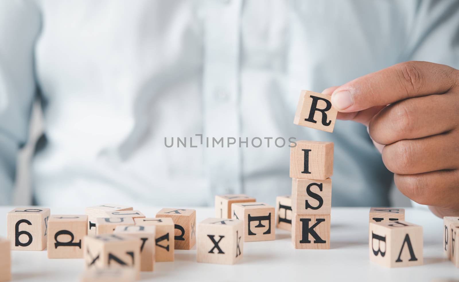 Hand hold wooden block with the word "RISK". Concept risk  by photobyphotoboy
