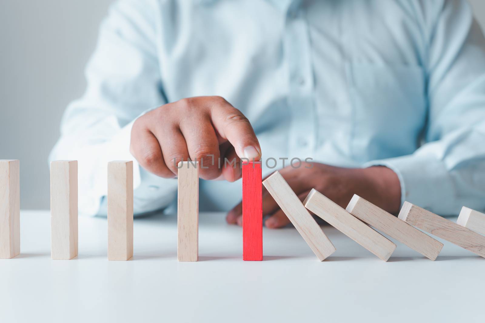 Businessman protect wooden block ,Business risks in the business by photobyphotoboy