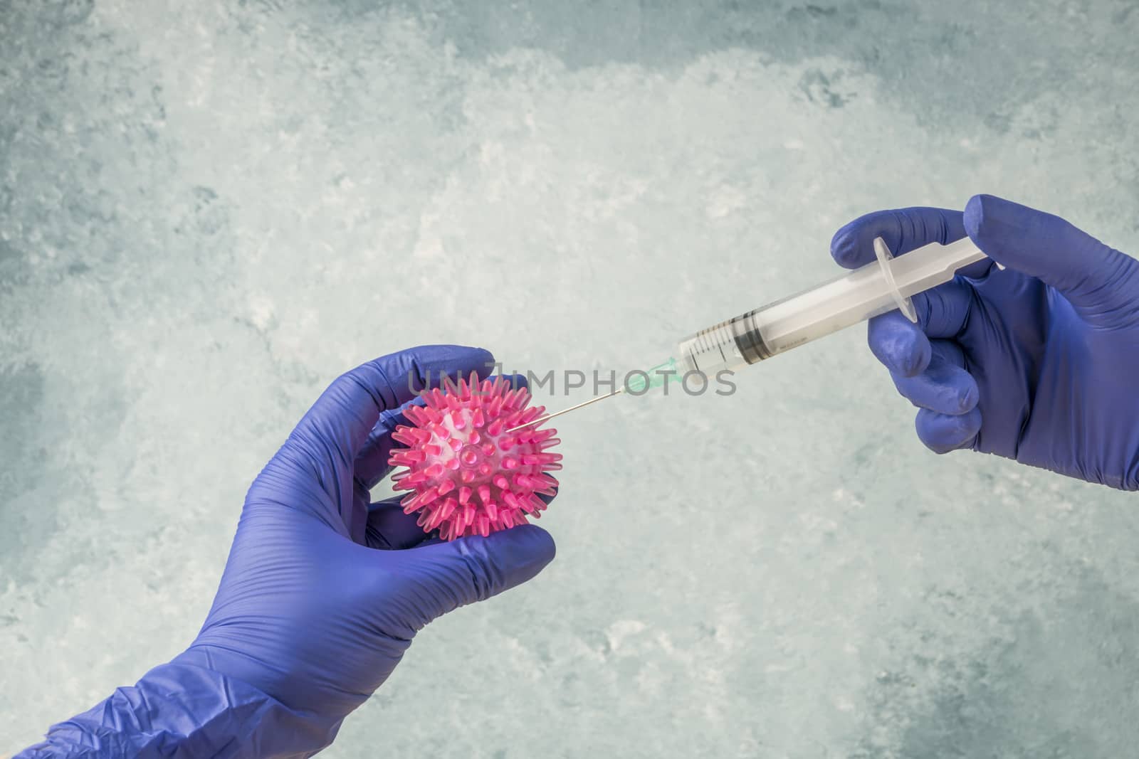hands in gloves applying injection into covid-19 corona virus by bernanamoglu