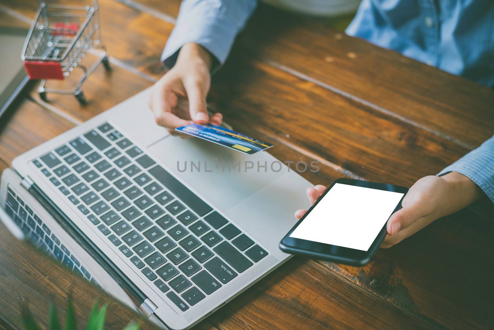 Woman holding credit cards and mobile phones are now shopping over the internet by paying by credit card.