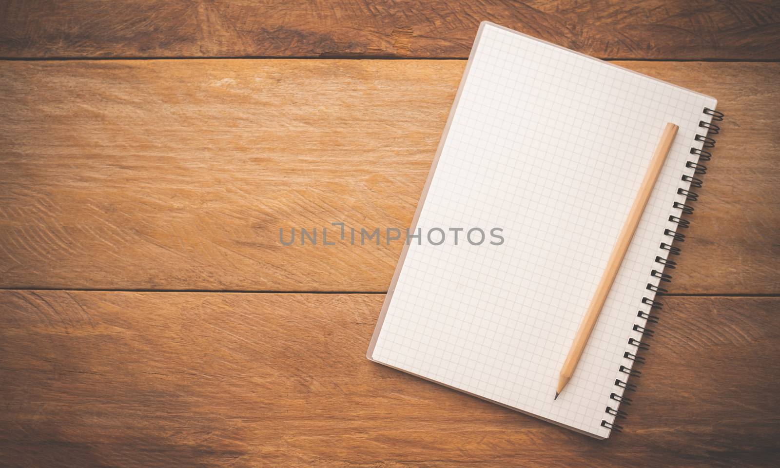 White notebooks and pencil laying on a wooden table by photobyphotoboy