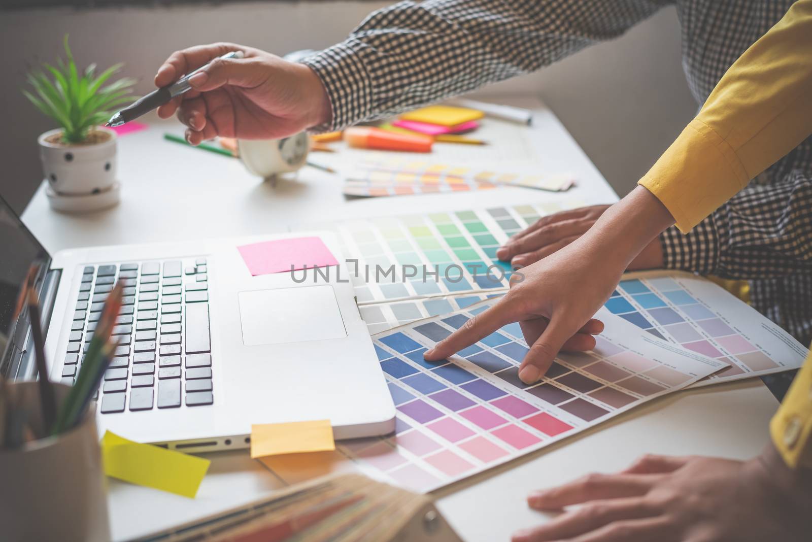 The graphic designer creative team is currently working on the design and color selection on the guide color for advertising design.