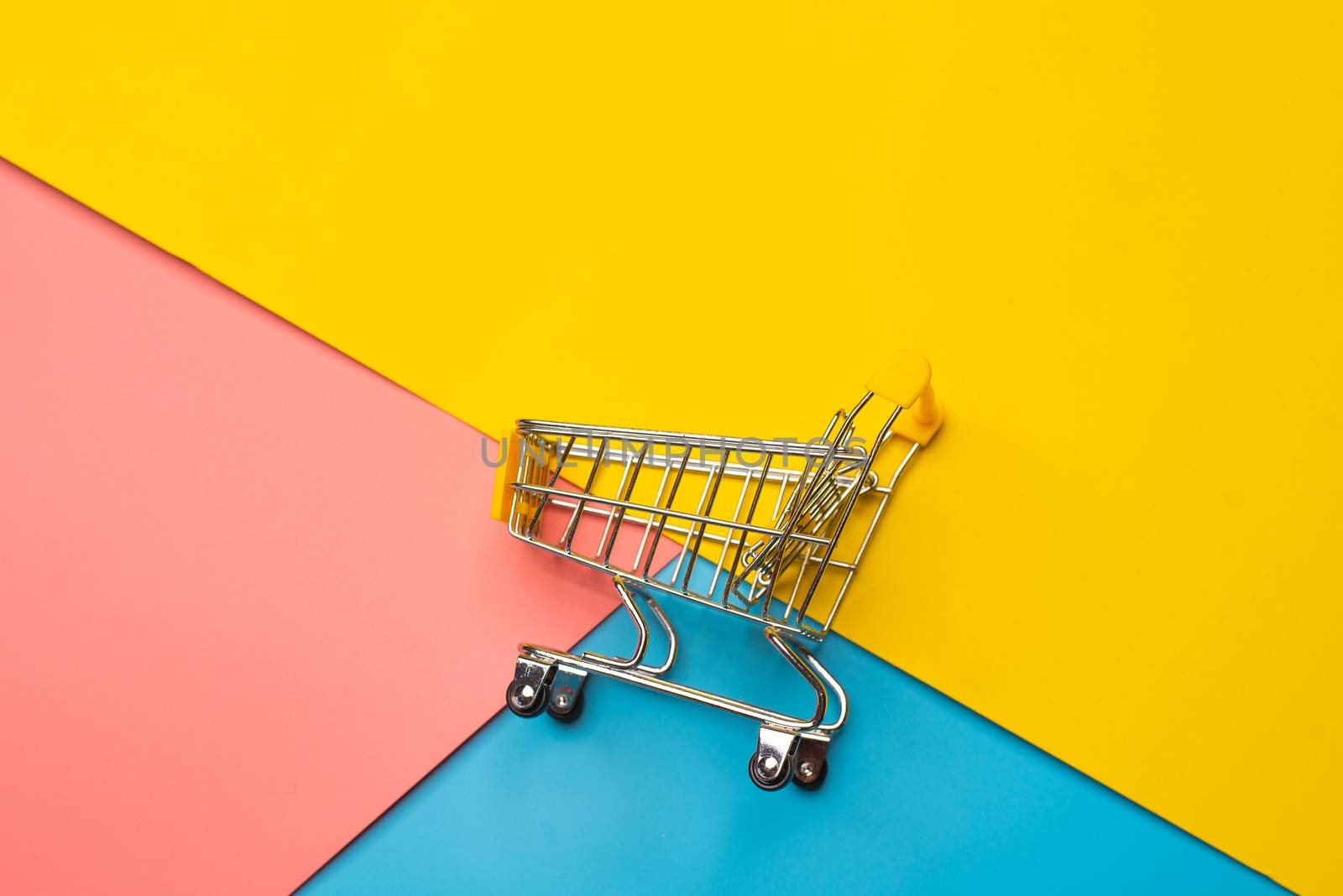 Top view for mini shopping cart on a colorful background.