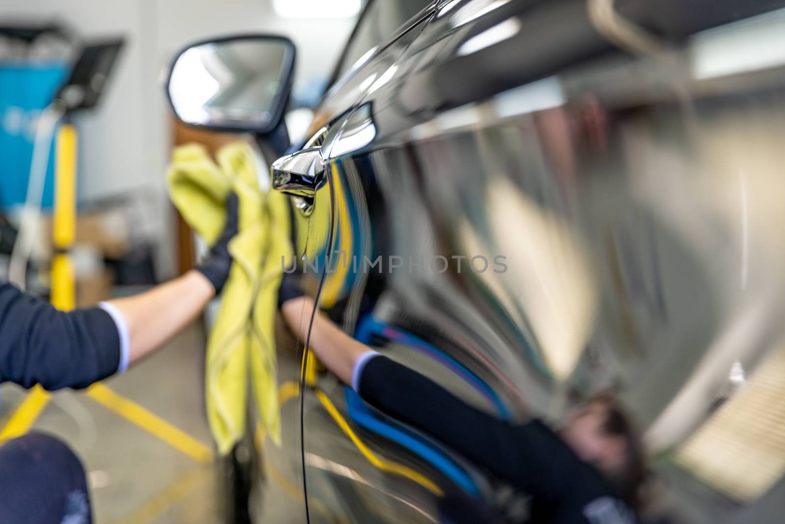 polishing the body of luxury cars with the help of a microfiber cloth for a perfect shine.