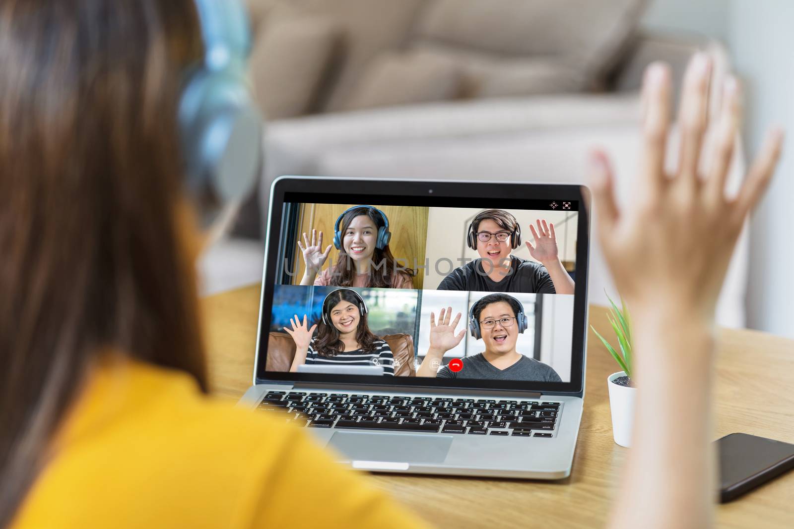 Rear View of Asian Business woman say hello with teamwork colleague in video conference when Coronavirus outbreak, Covid-19 pandemic, online meeting, Social distancing and new normal concept