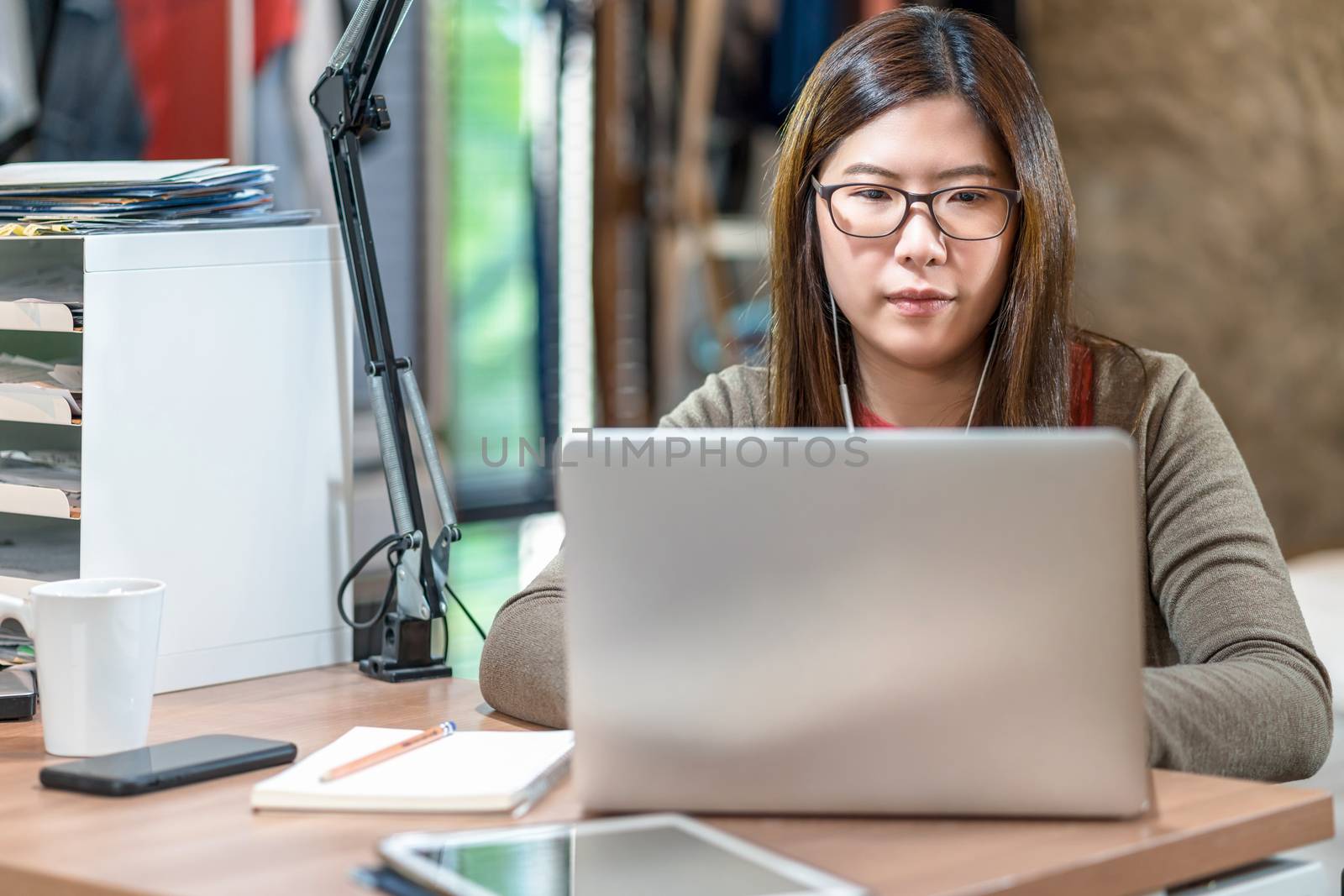 Asian business woman using technology laptop and working from ho by Tzido