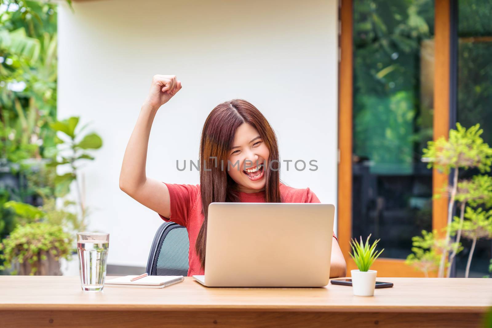 Asian business woman using technology laptop and celebrating whe by Tzido