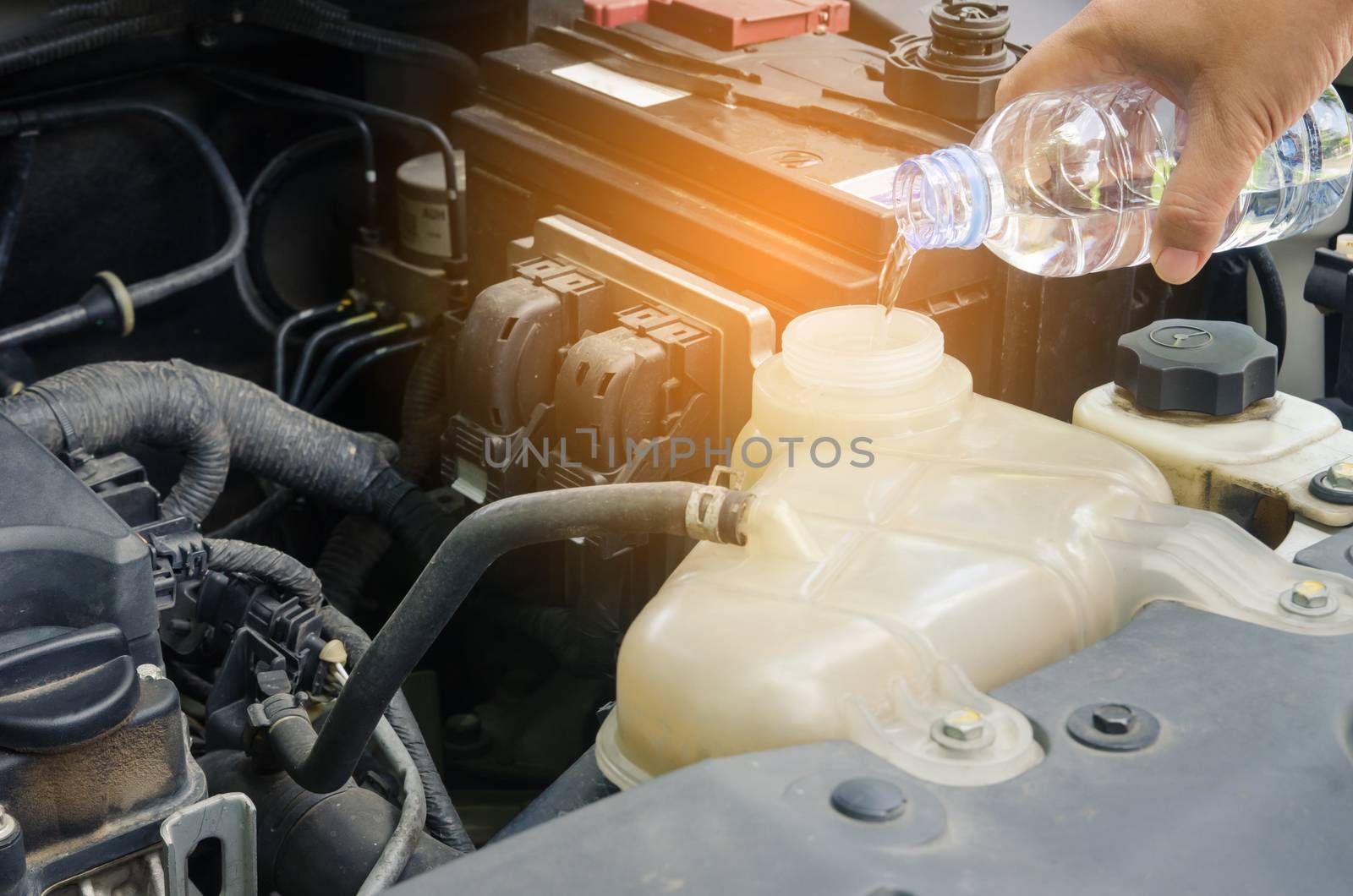 women filling water to car radiator. concept for safety before travel