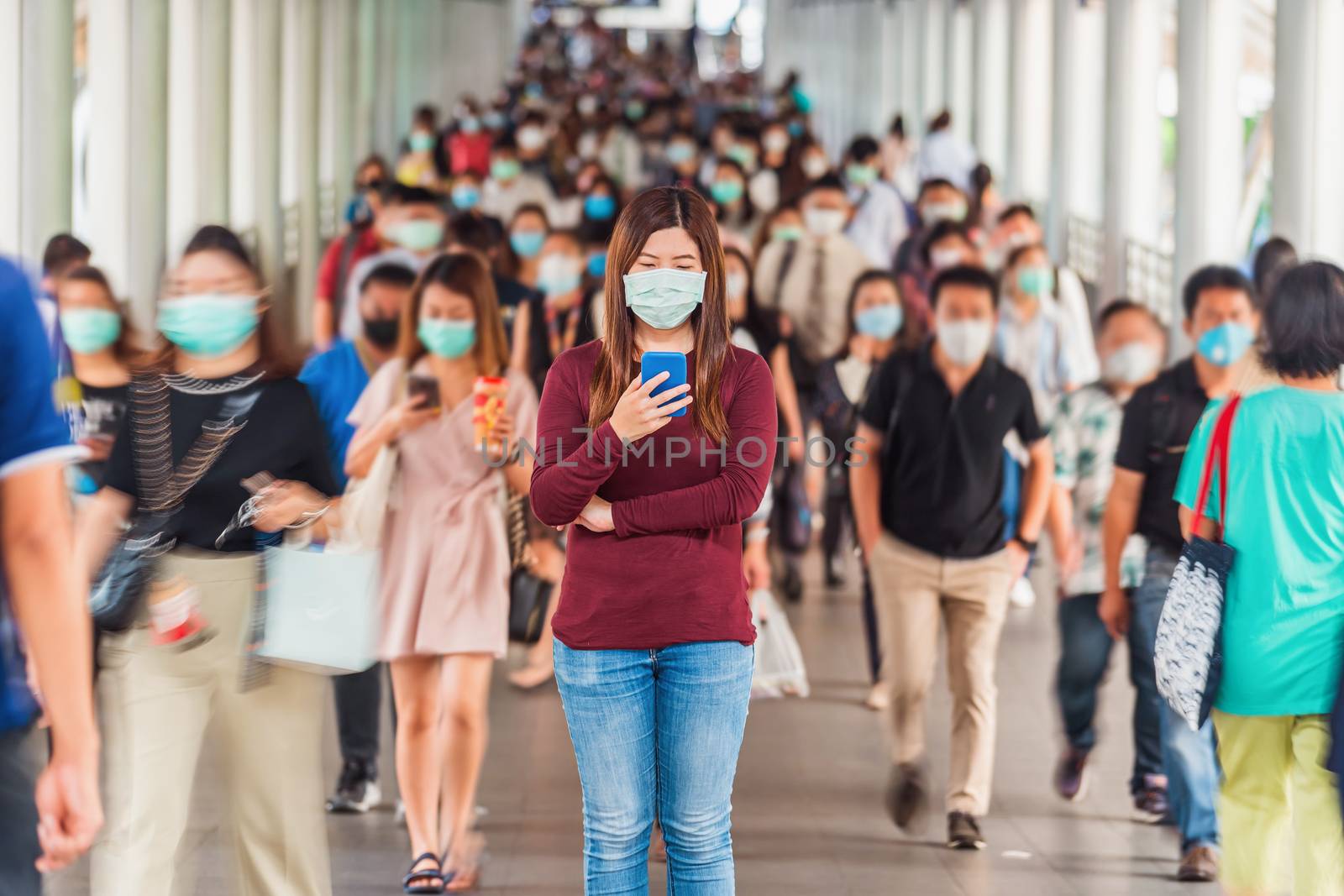 Asian woman using mobile phone between Crowd of blurred unrecogn by Tzido