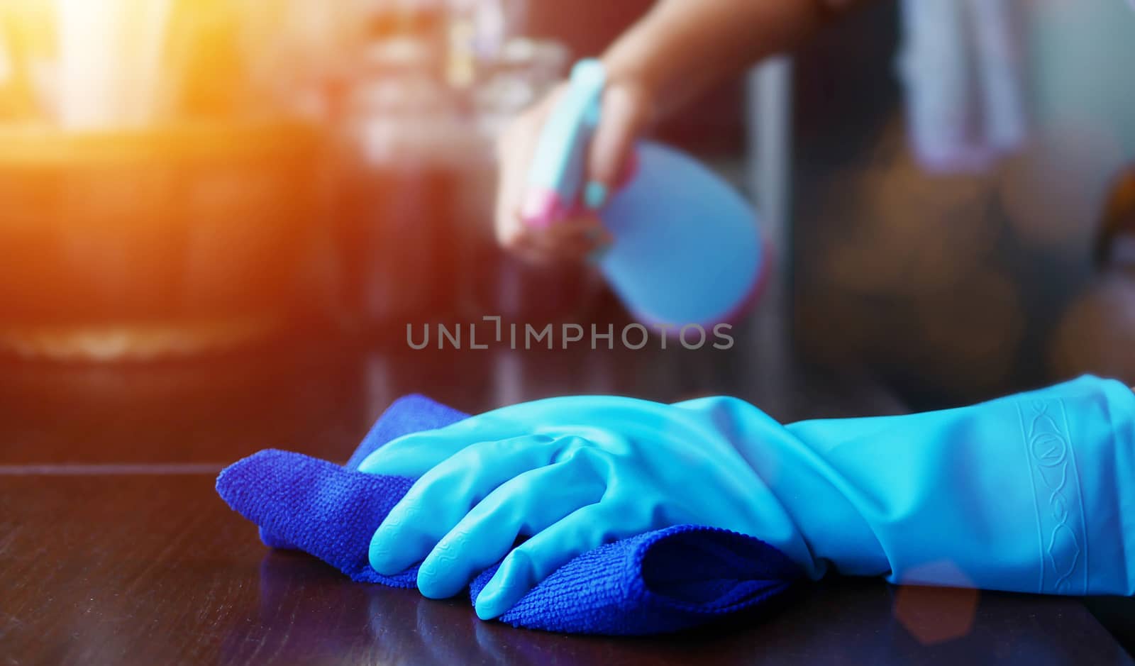 hand in blue rubber glove holding blue microfiber cleaning cloth by asiandelight