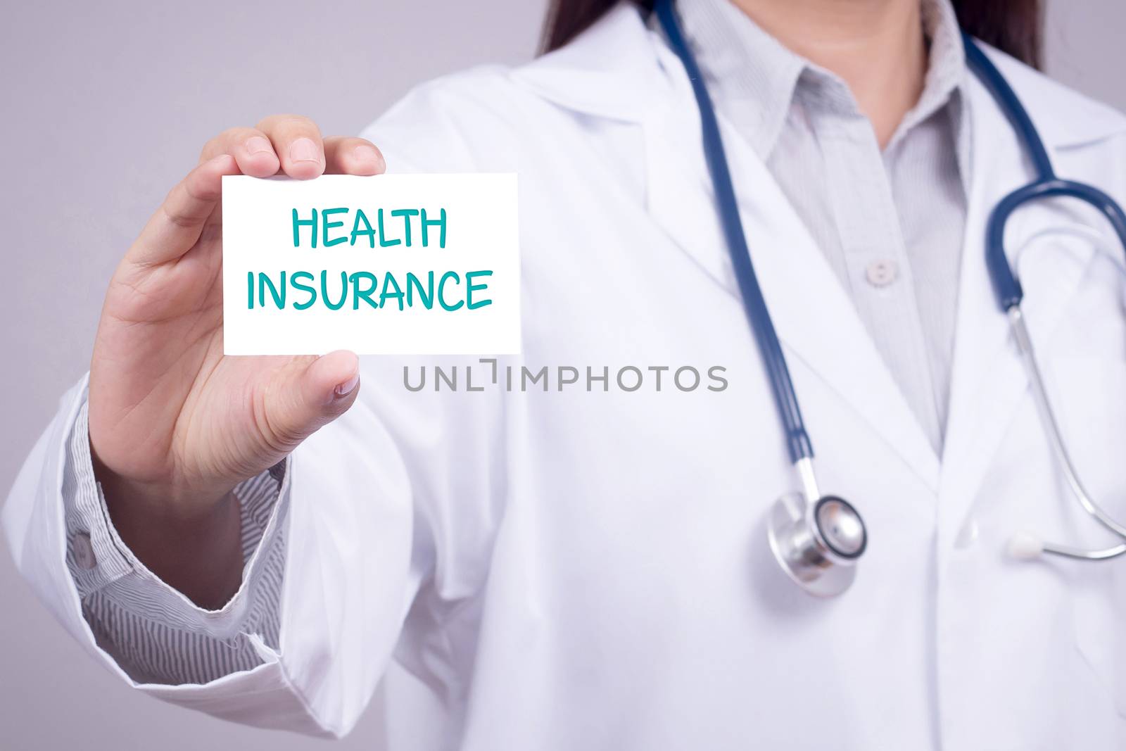 health insurance concept. doctor in medical clothing with stethoscope showing card for health insurance in hand, anonymous face