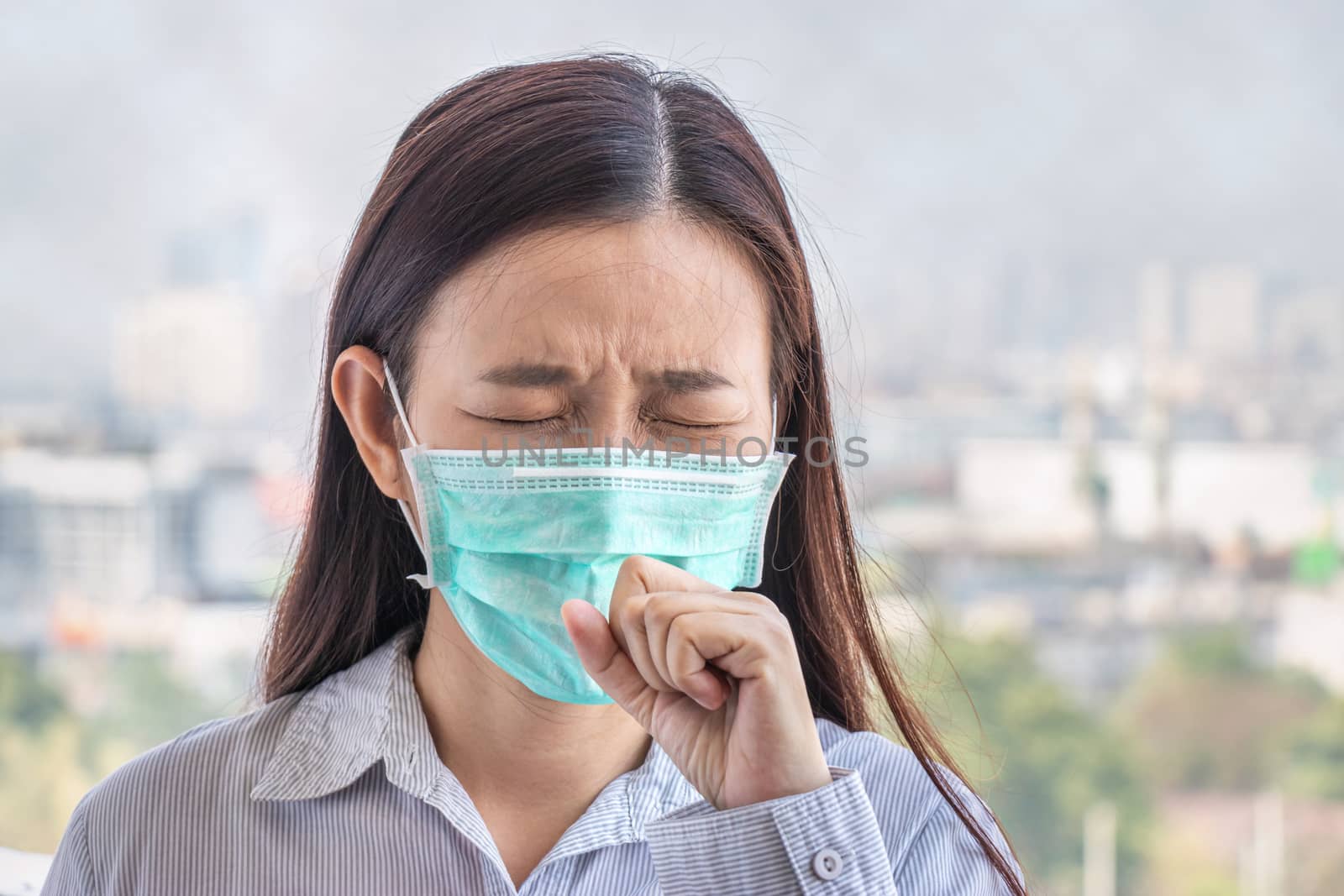 PM2.5. people feeling sick from air pollution, environment has harmful or poisonous effects. woman in the city wearing face mask to protect herself because level of pollution in the air is rising.