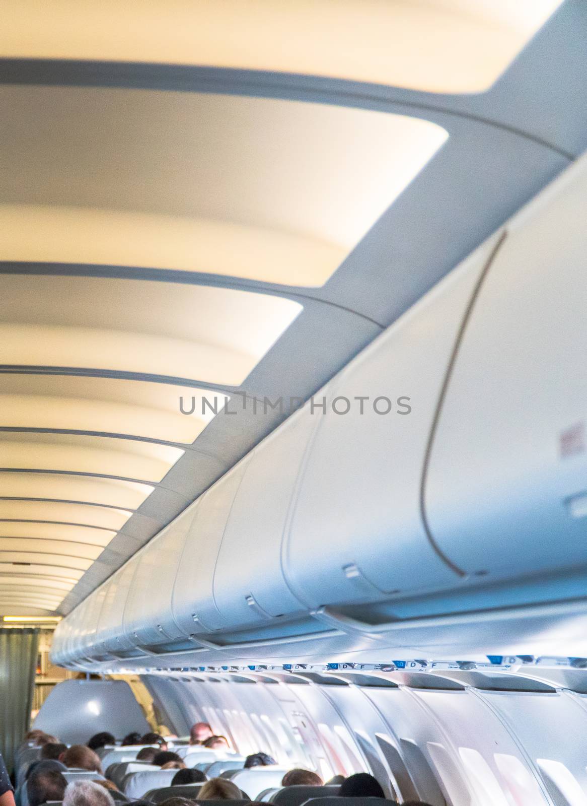 Blurred photo of the aircraft interior. The ceiling of the airplane with luggage compartment
