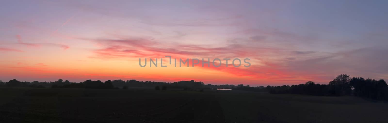 Beautiful high resolution panorama of a northern european country landscape with fields and green grass.