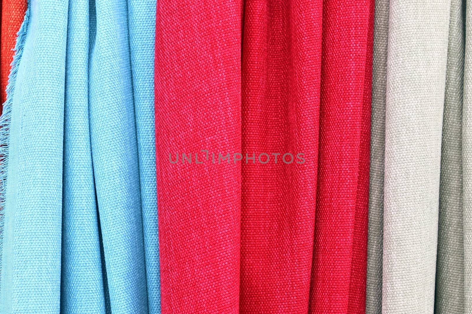 Detailed close up view on samples of cloth and fabrics in different colors found at a fabrics market.