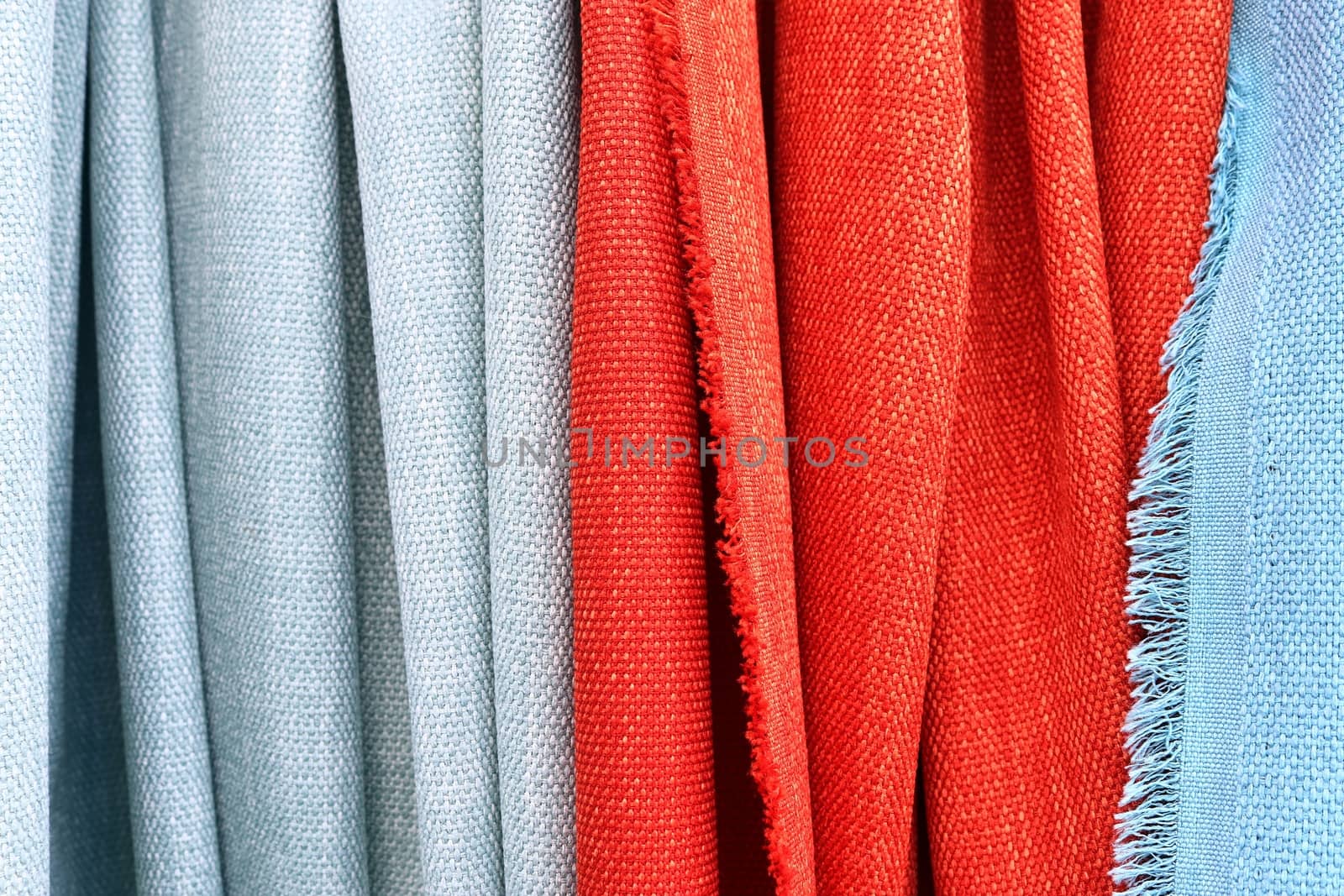 Detailed close up view on samples of cloth and fabrics in different colors found at a fabrics market.