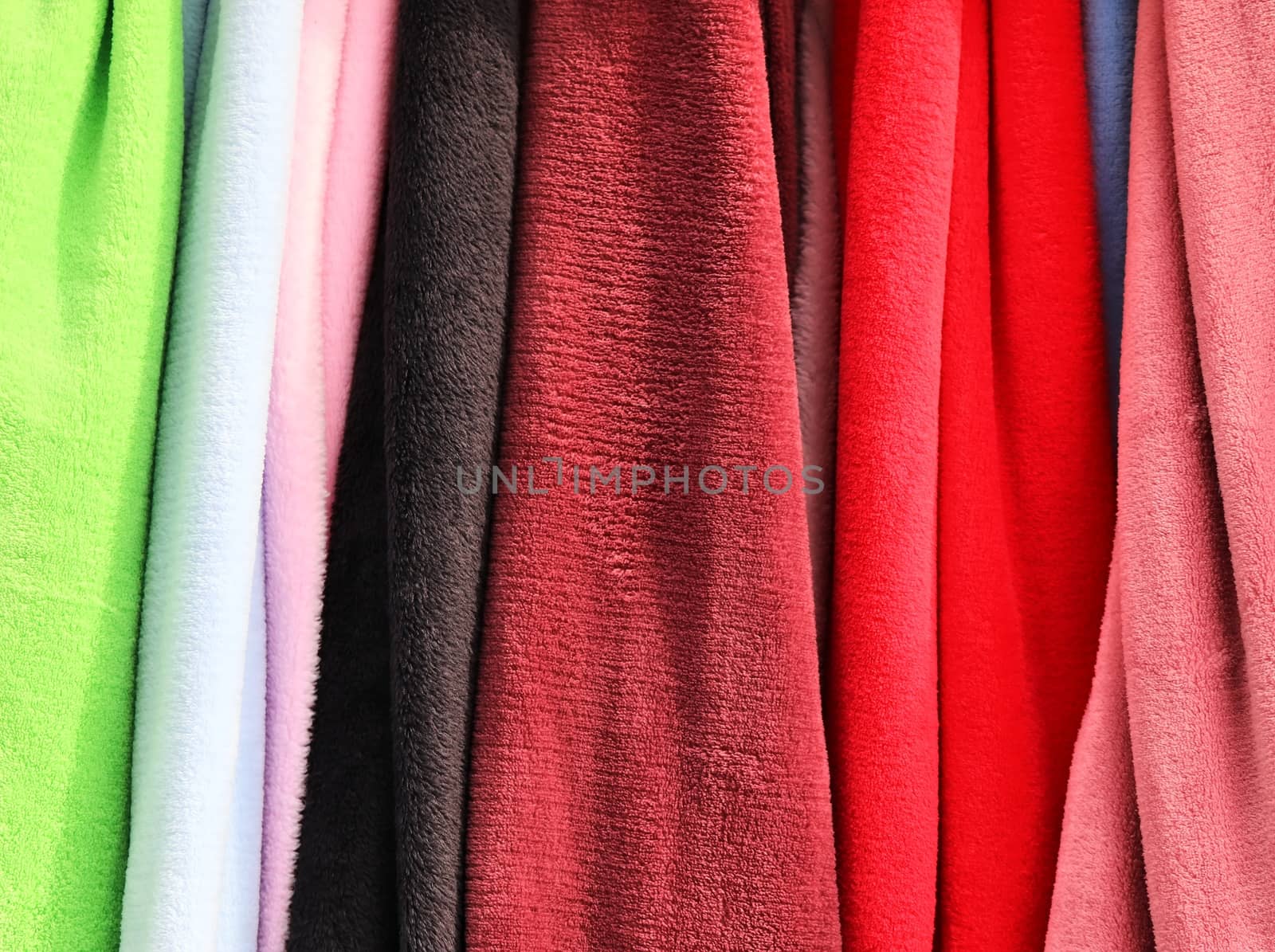 Detailed close up view on samples of cloth and fabrics in different colors found at a fabrics market.