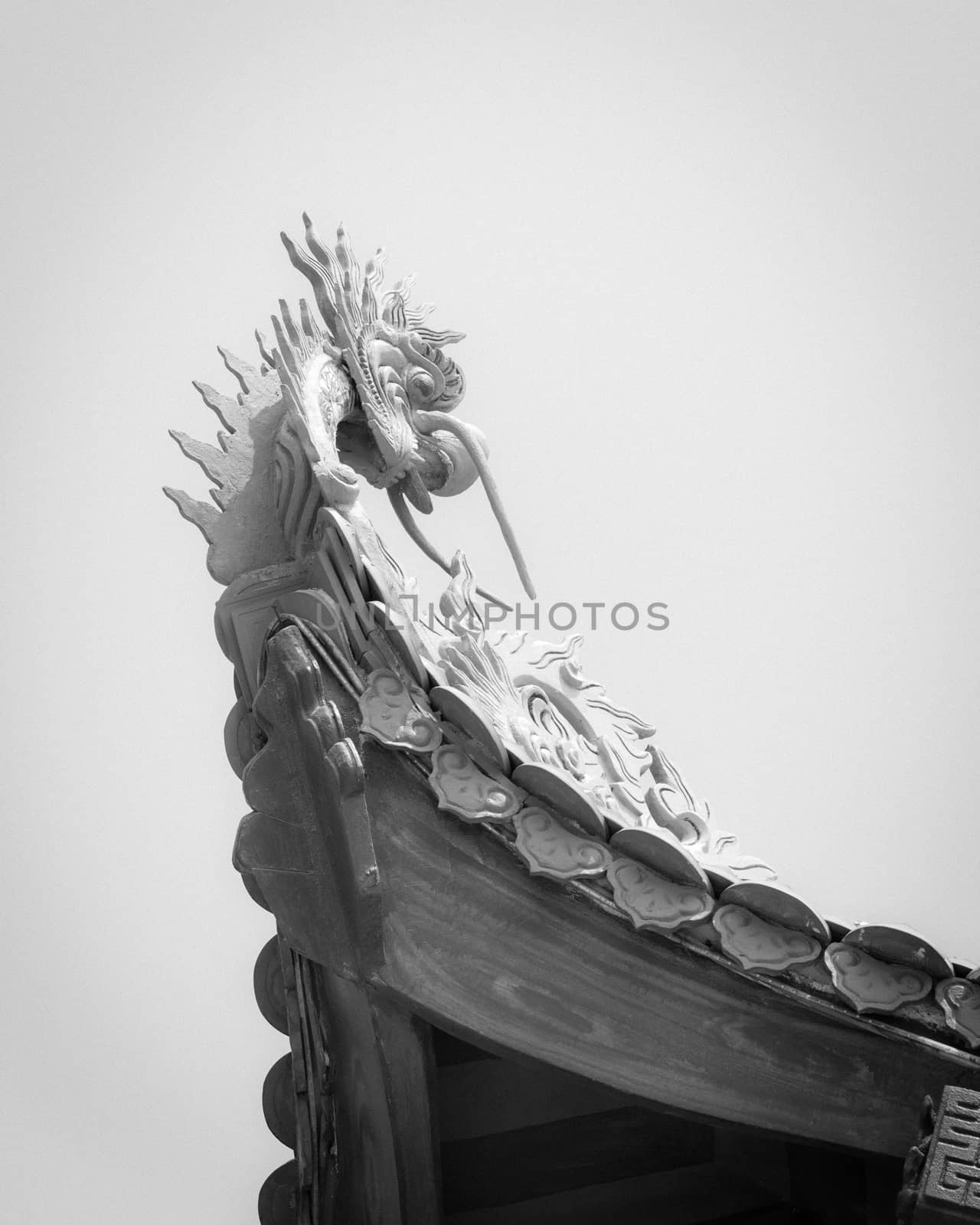 Toned photo typical cornice roof of Asian temple with dragon head shape, ancient tile roof and wooden structure. Look up view traditional pagoda exterior in the North Vietnam.