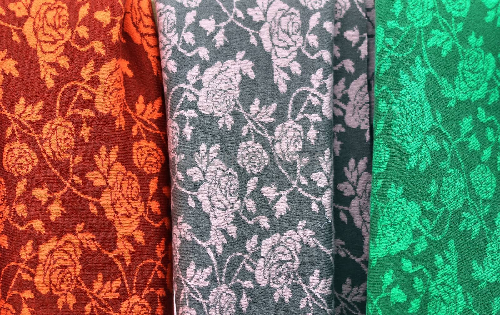 Detailed close up view on samples of cloth and fabrics in different colors found at a fabrics market.