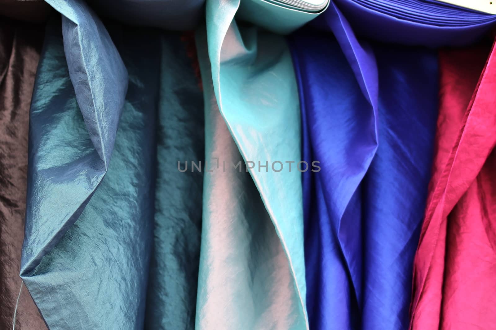 Detailed close up view on samples of cloth and fabrics in different colors found at a fabrics market.