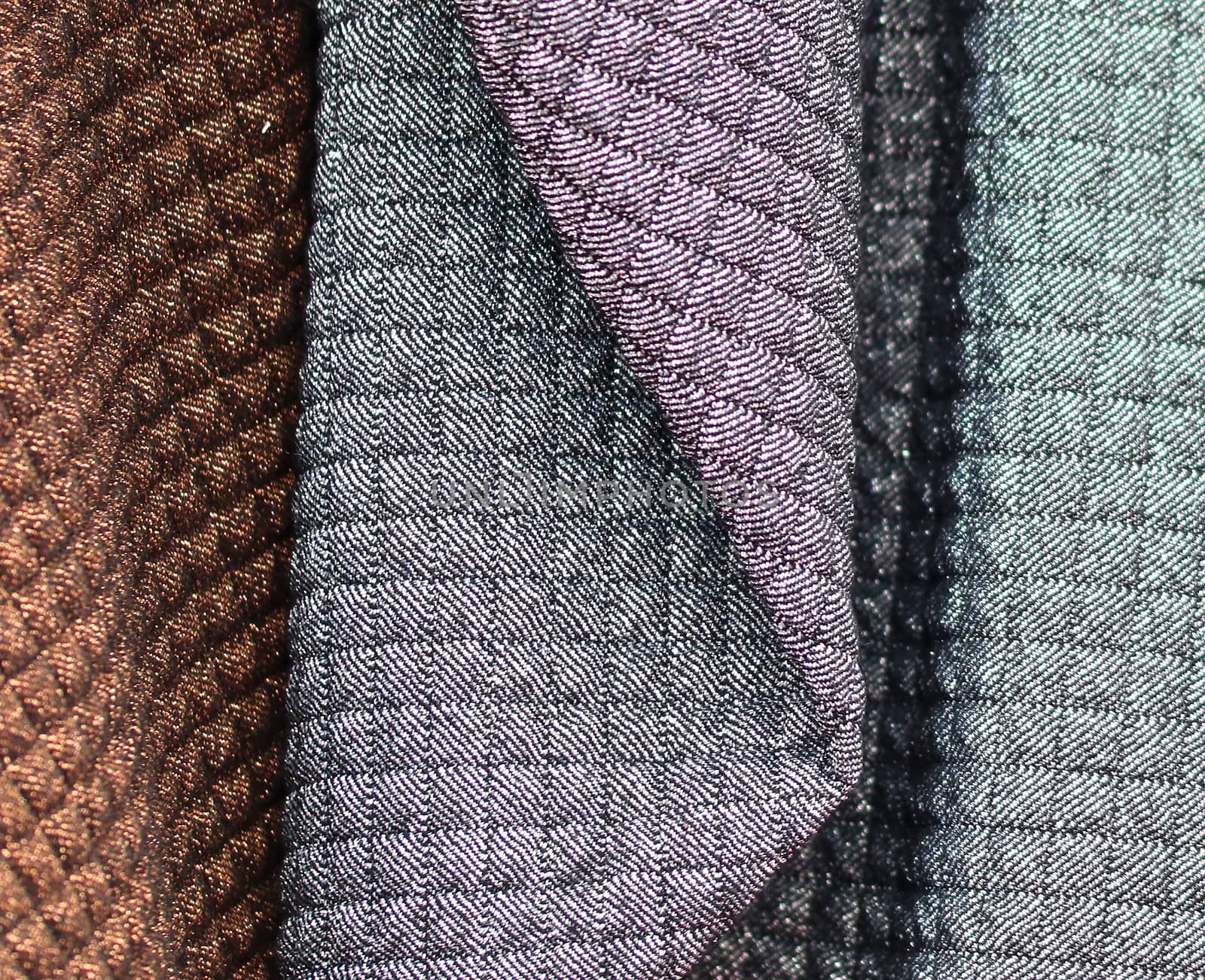 Detailed close up view on samples of cloth and fabrics in different colors found at a fabrics market.