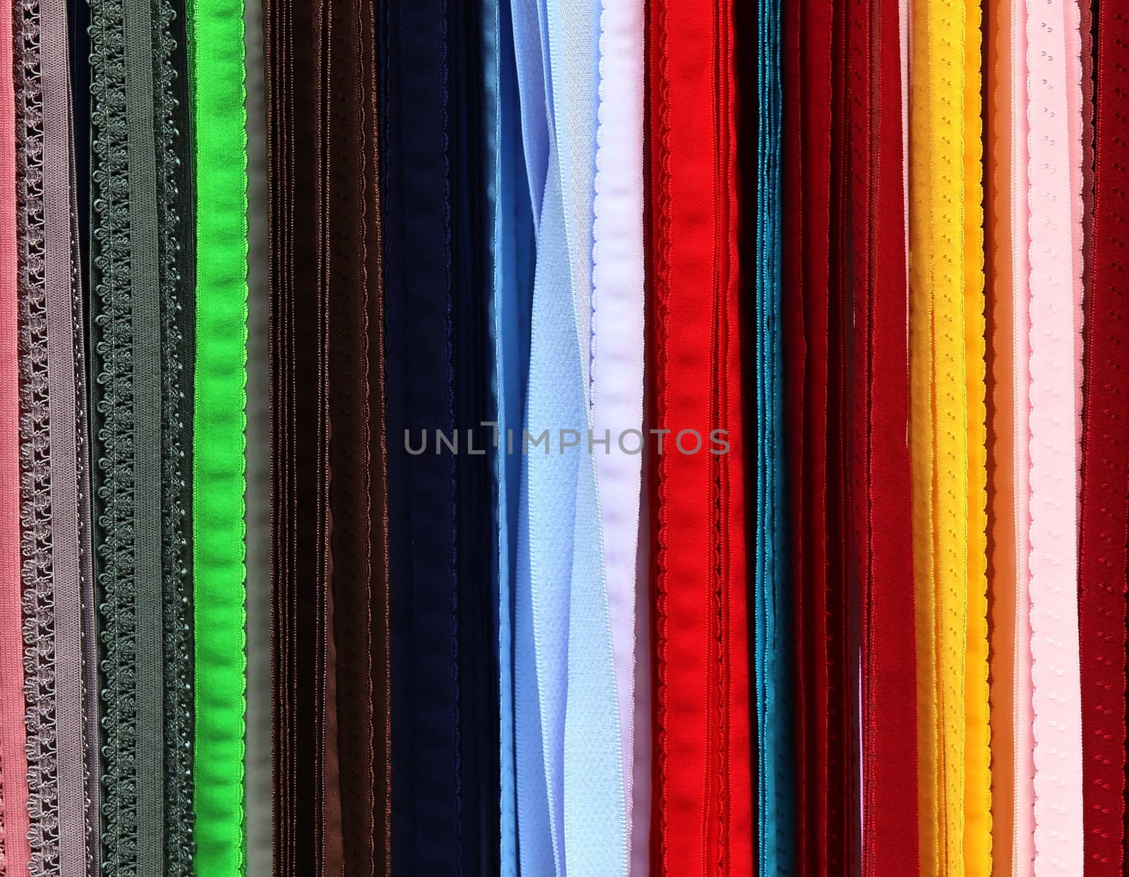 Detailed close up view on samples of cloth and fabrics in different colors found at a fabrics market.