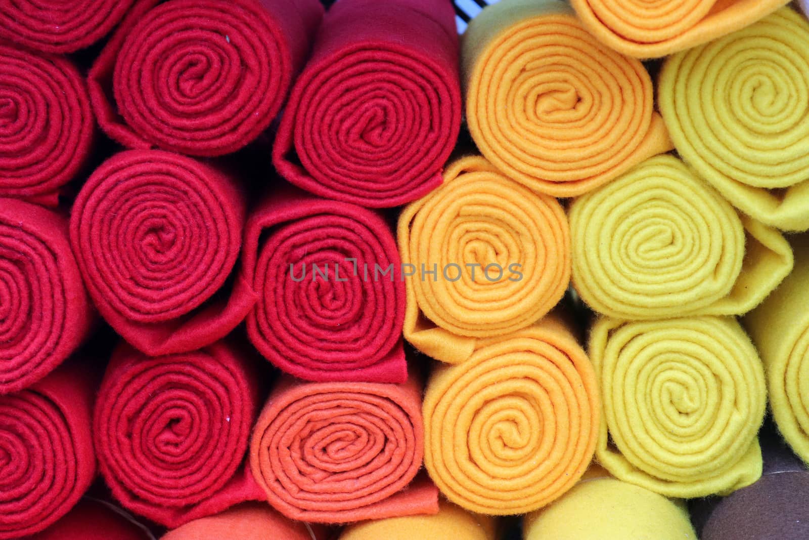 Detailed close up view on samples of cloth and fabrics in different colors found at a fabrics market.