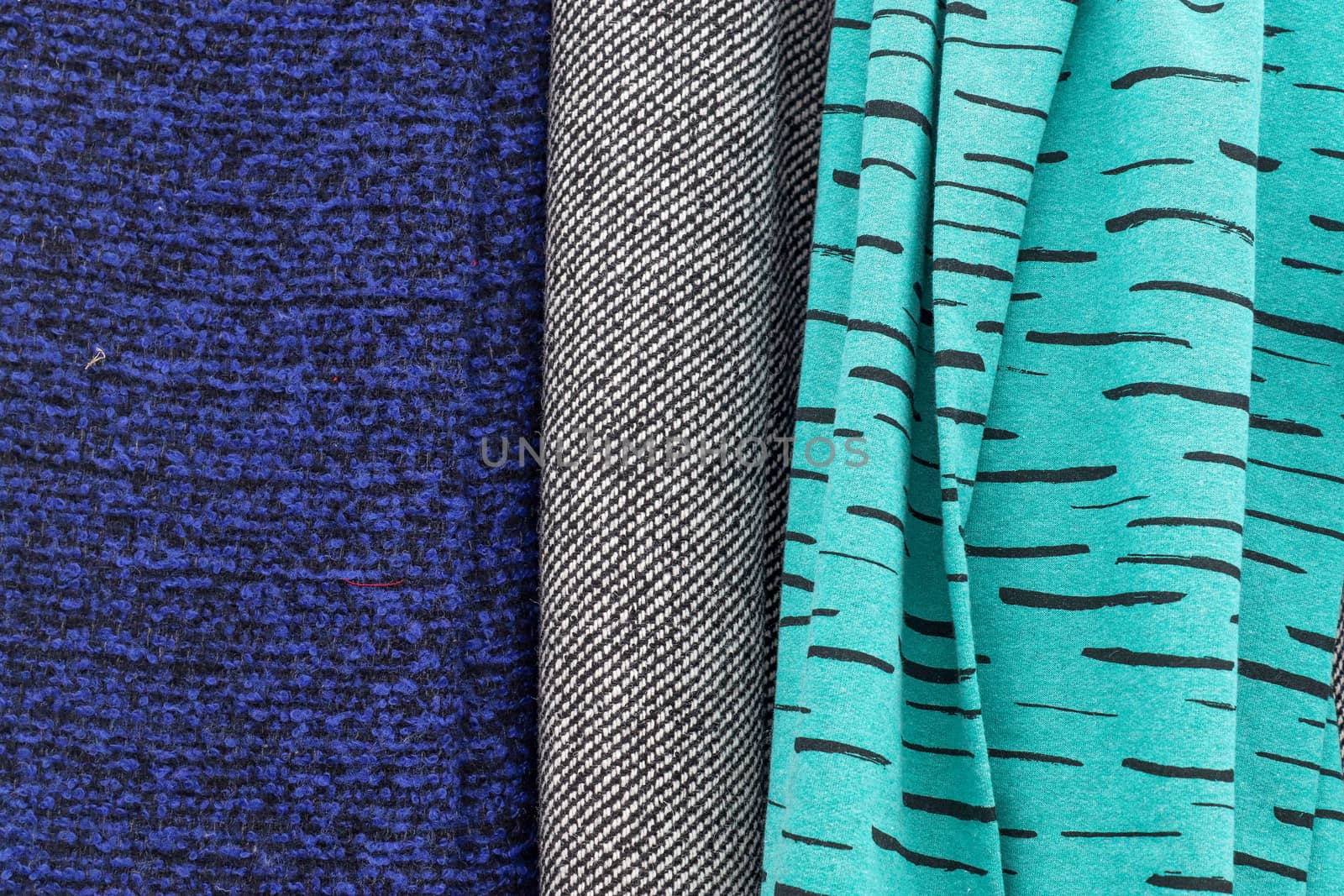 Detailed close up view on samples of cloth and fabrics in different colors found at a fabrics market.