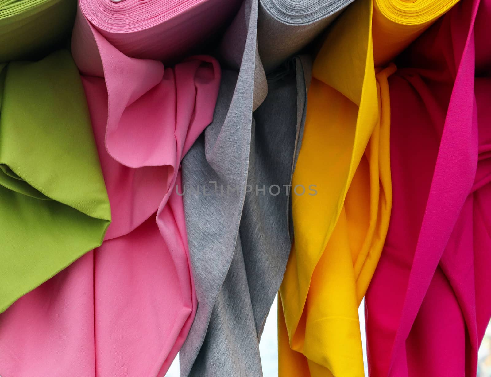 Detailed close up view on samples of cloth and fabrics in different colors found at a fabrics market.