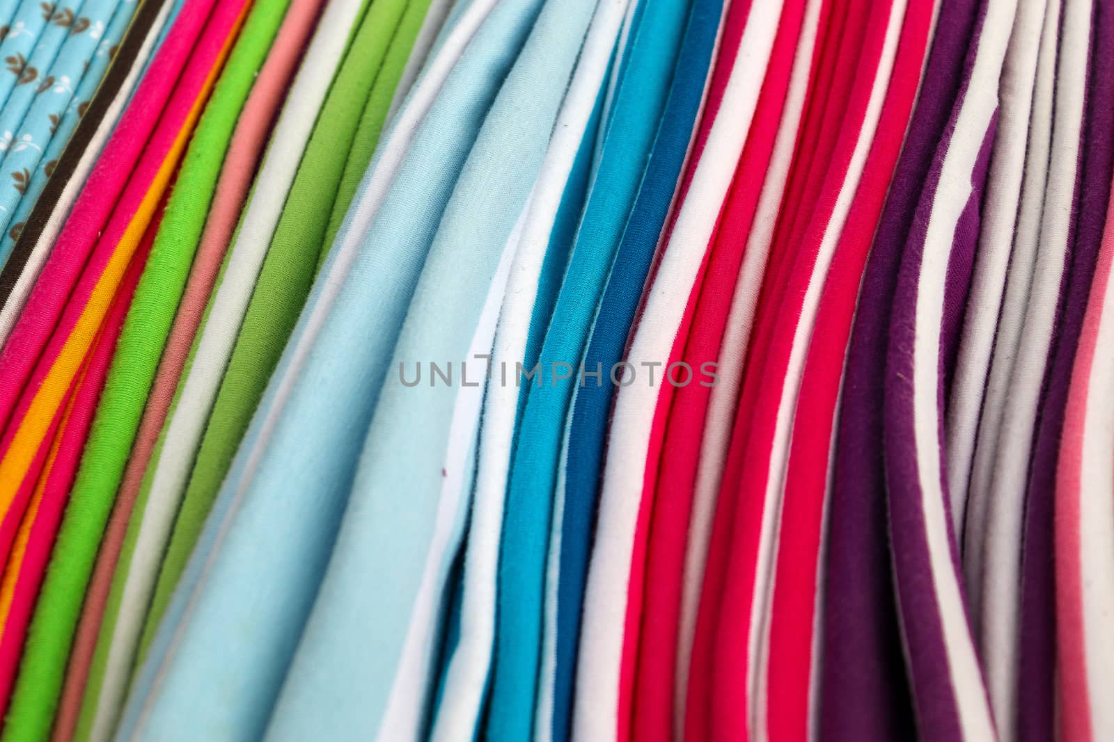 Detailed close up view on samples of cloth and fabrics in different colors found at a fabrics market.