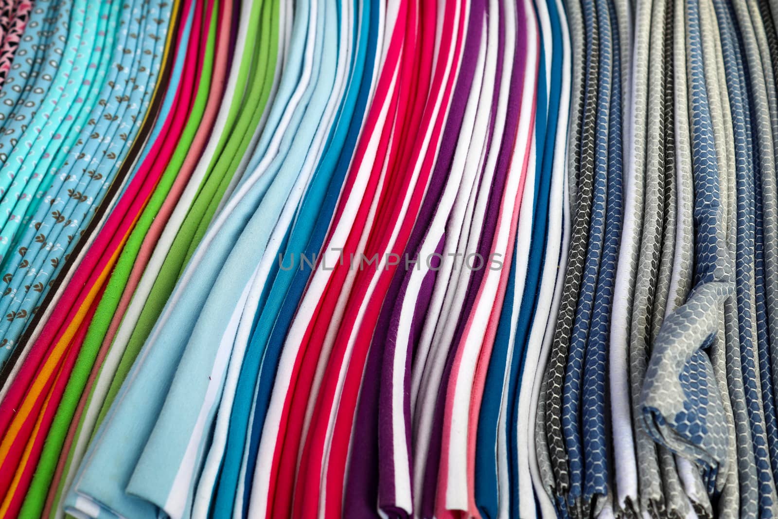 Detailed close up view on samples of cloth and fabrics in different colors found at a fabrics market.