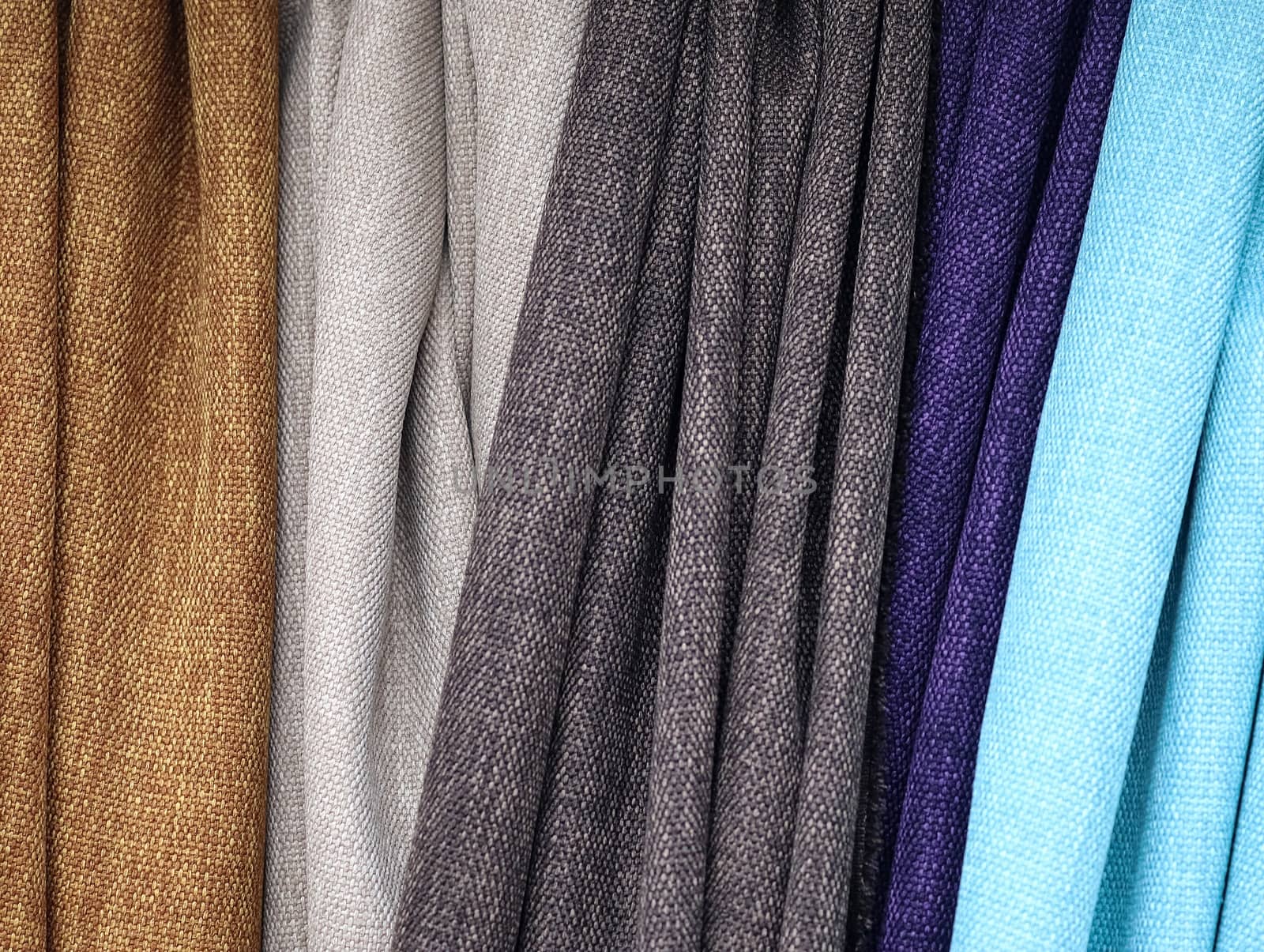 Detailed close up view on samples of cloth and fabrics in different colors found at a fabrics market.