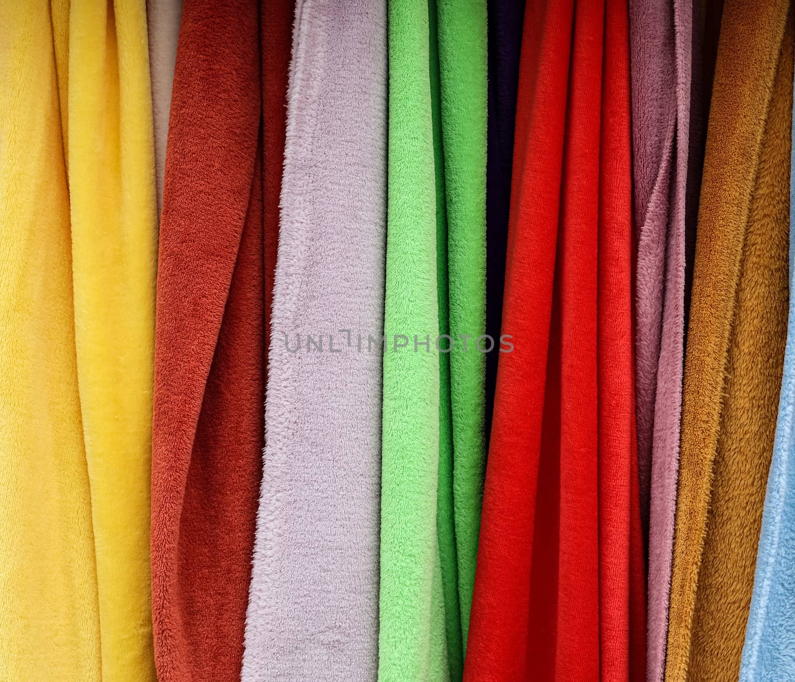 Detailed close up view on samples of cloth and fabrics in different colors found at a fabrics market.