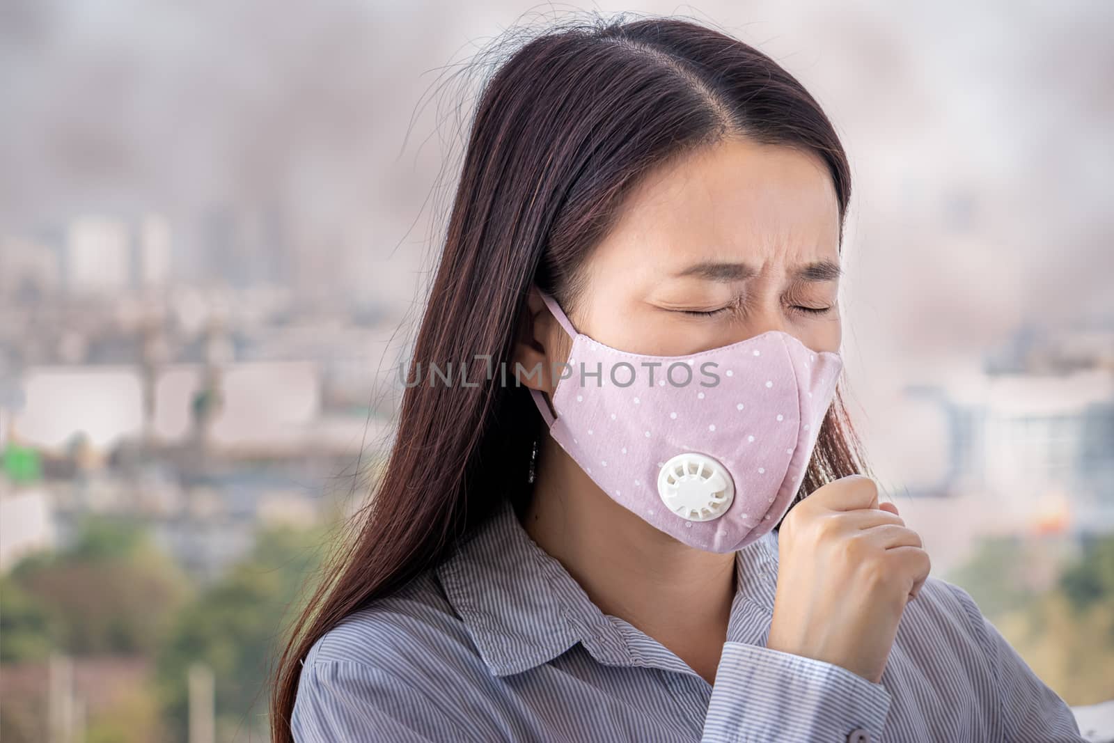 PM2.5. people feeling sick from air pollution, environment has harmful or poisonous effects. woman in the city wearing face mask to protect herself because level of pollution in the air is rising.