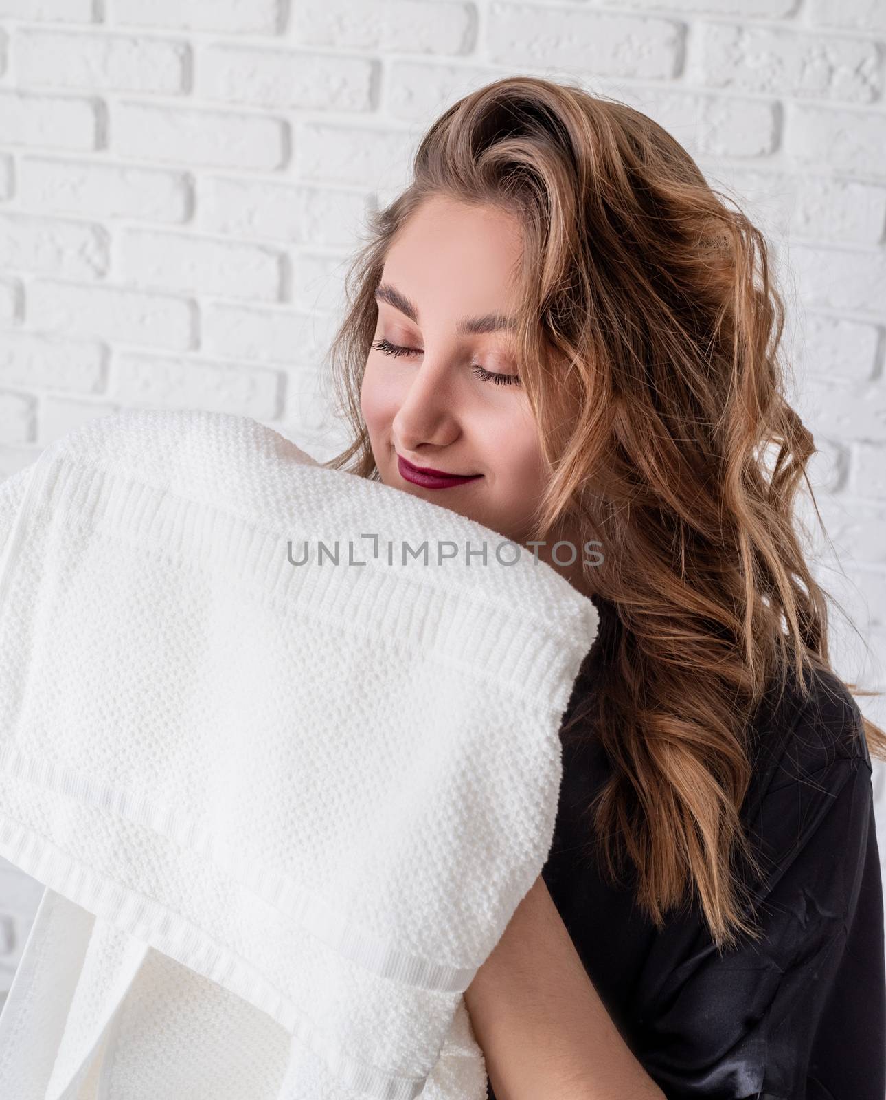 beautiful woman smelling clean clothes at home by Desperada