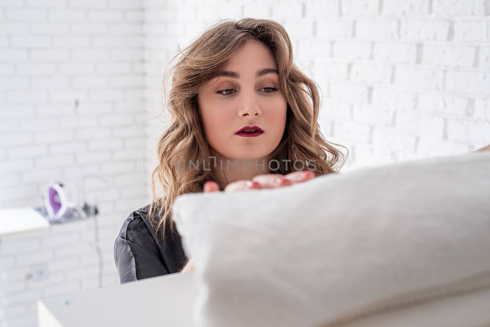 young attractive woman ironing at home with copy space by Desperada