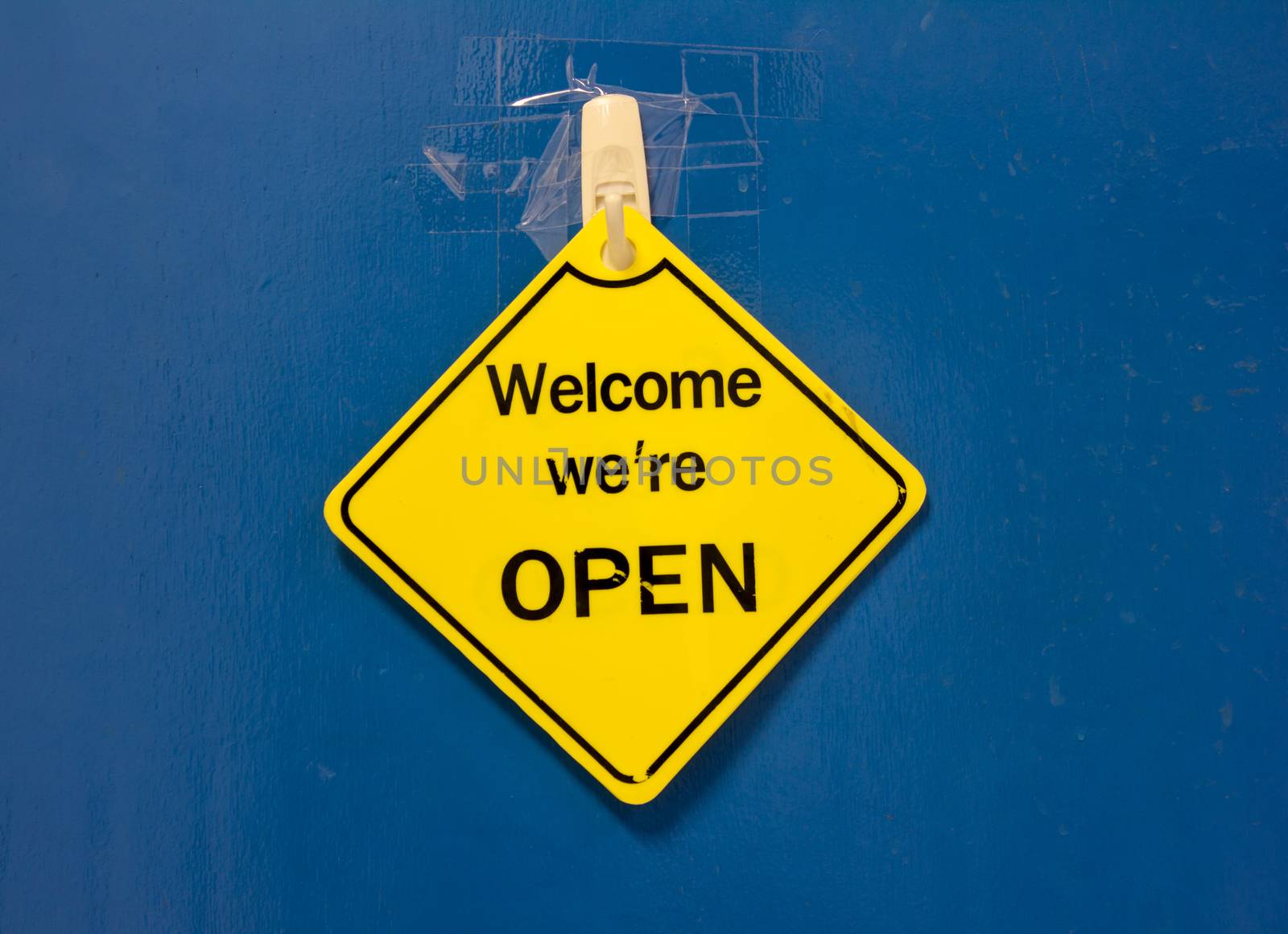 sign saying open against a blue door