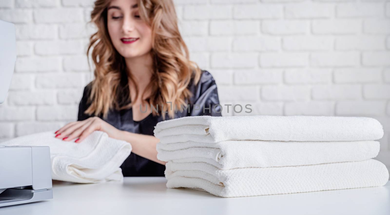 Beautiful housewife sewing towels at home using a sewing machine. Selective focus