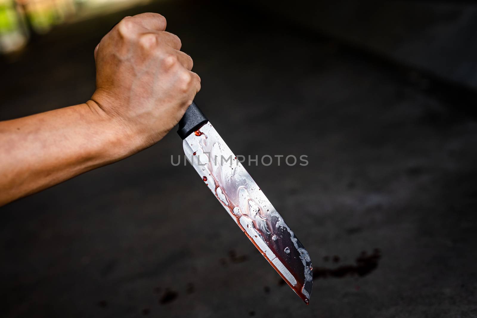 Close-up of the knife with blood stains and dripping on the floor.