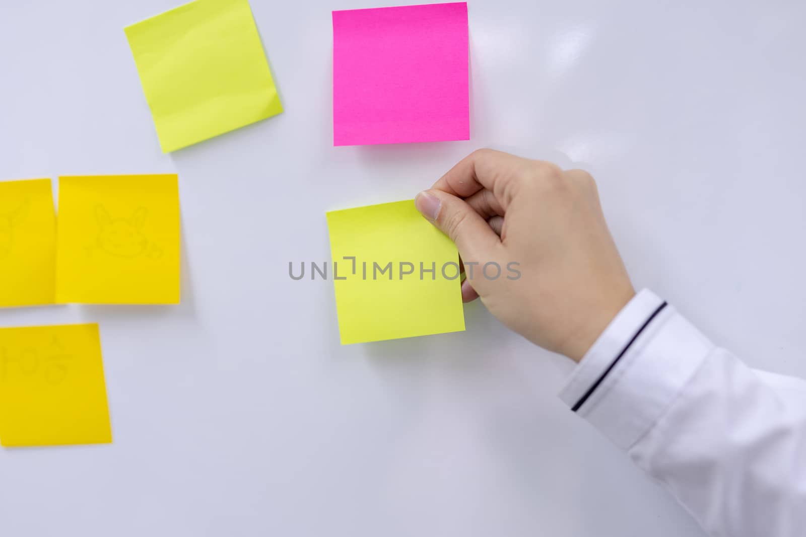Post-it note with hand on white background