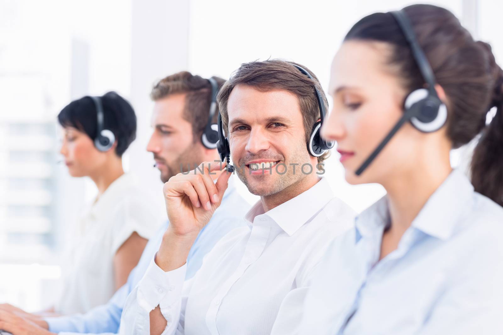 Business colleagues with headsets in a row by Wavebreakmedia
