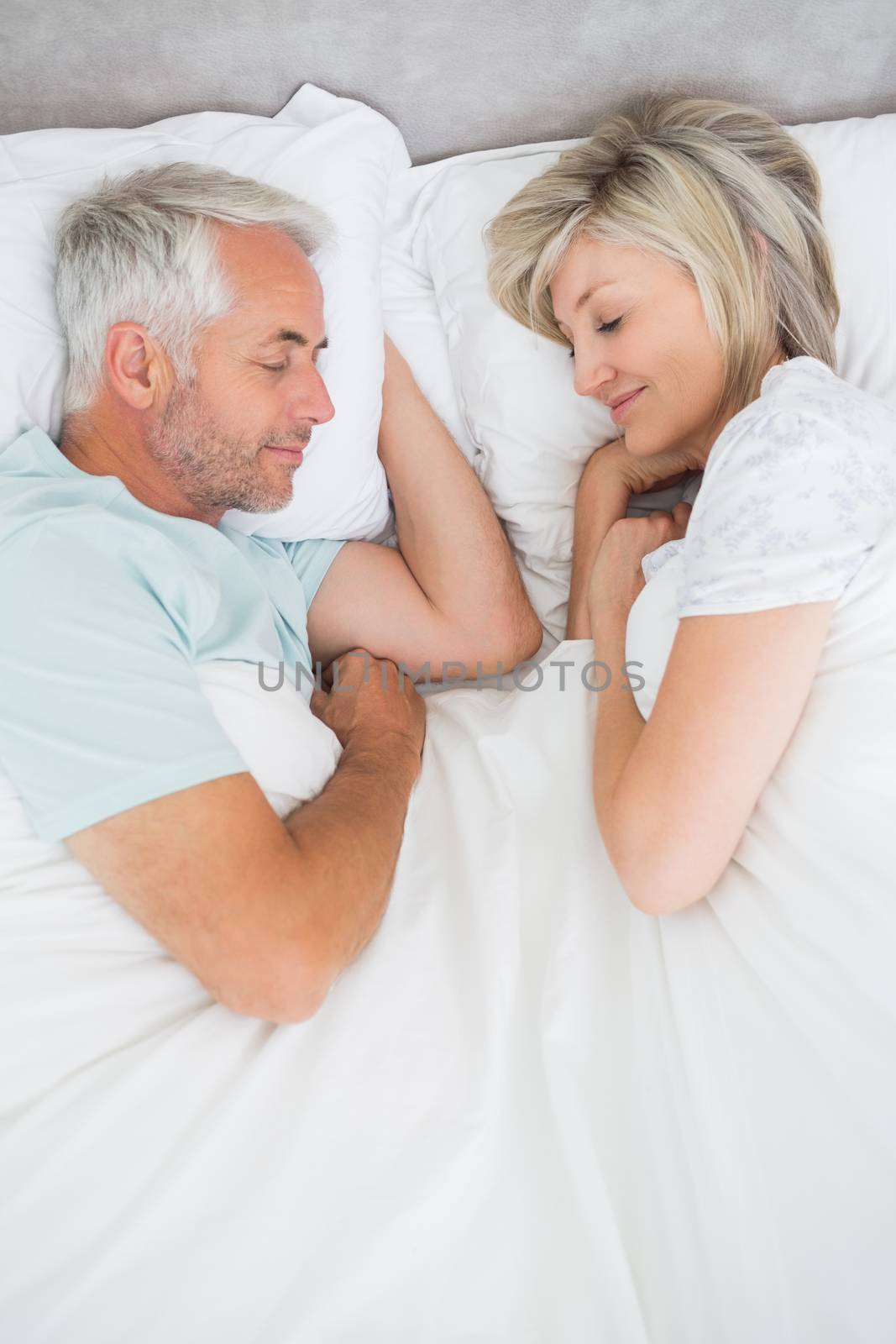 High angle view of a mature couple lying in bed at home