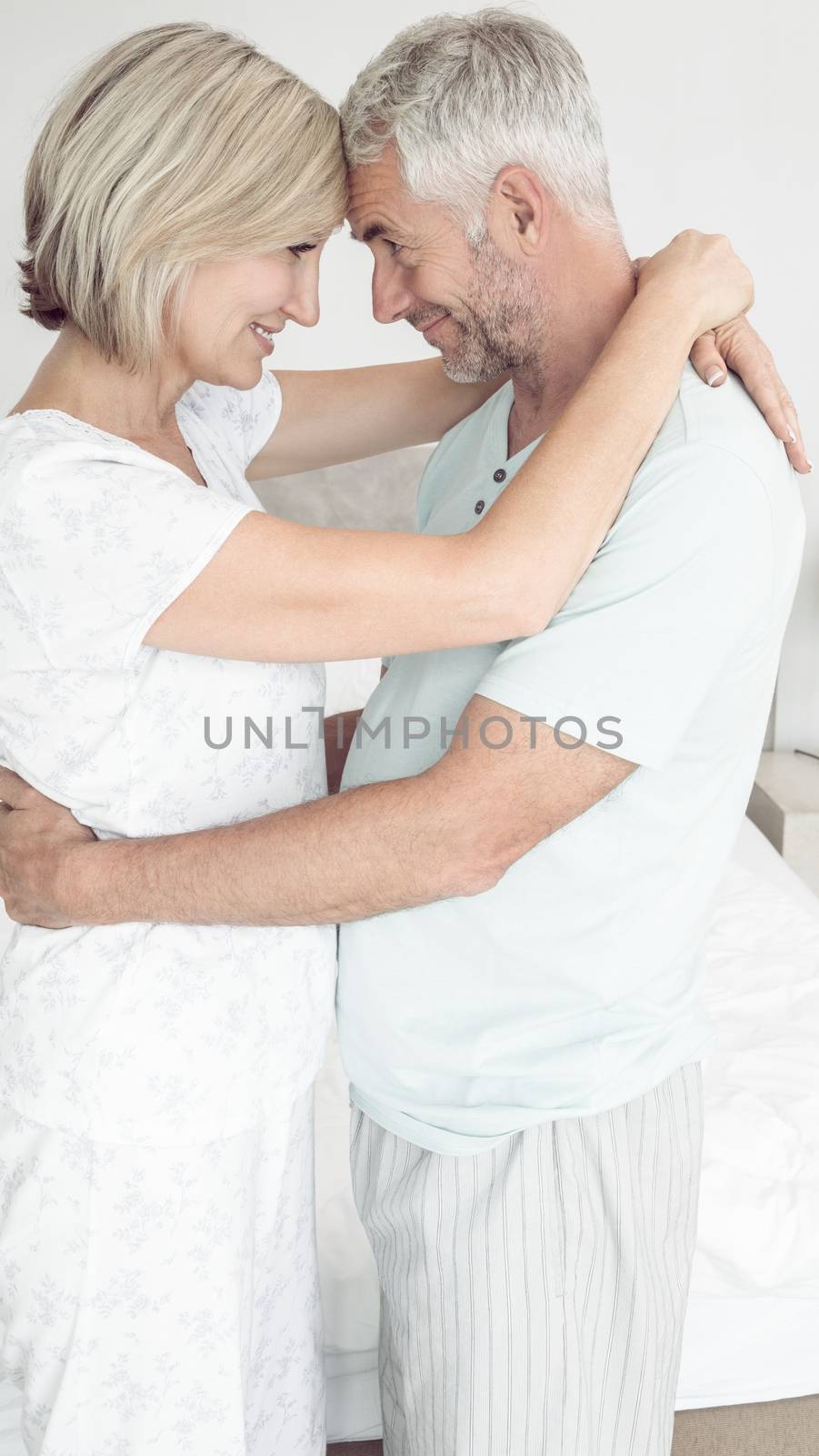 Side view of a loving mature couple with arms around at home