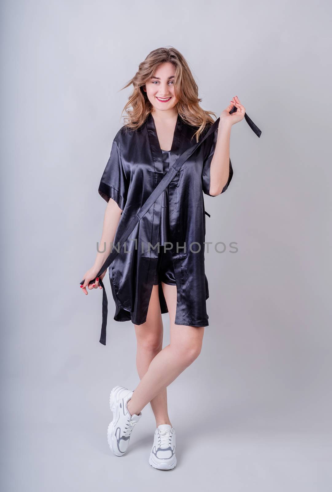 Laundry concept. Sexy housewife in black pajamas isolated on gray background