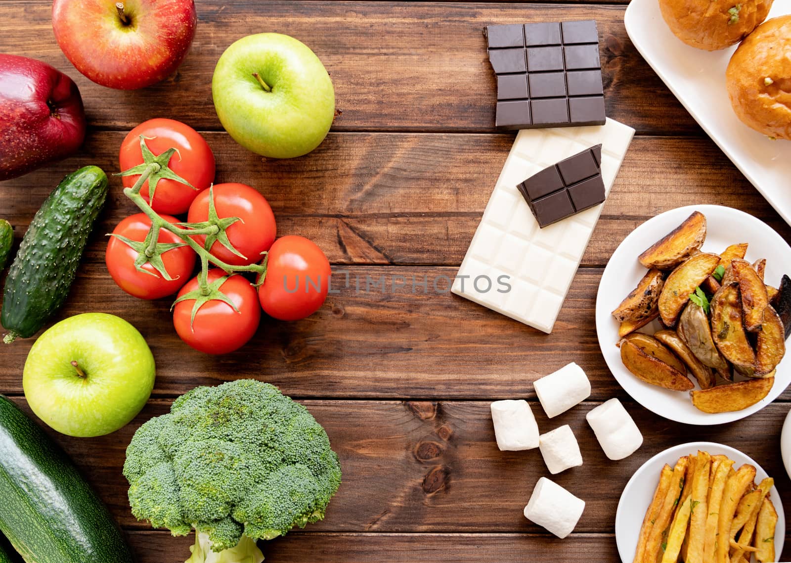 Healthy and unhealthy food concept. Fruit and vegetables vs sweets and potatoe fries top view flat lay on rustic background