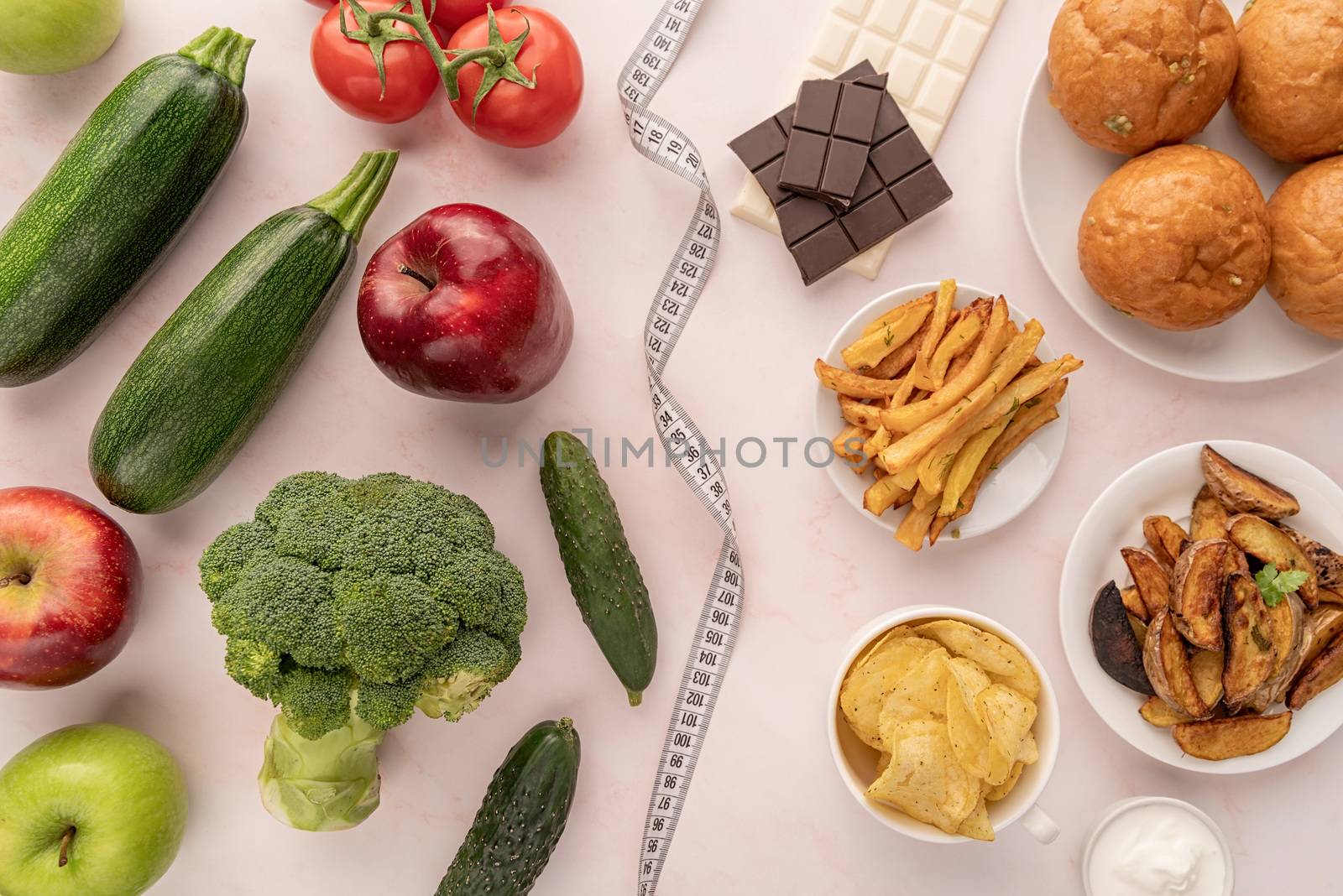 Healthy and unhealthy food concept. Fruit and vegetables vs sweets and potato fries top view flat lay by Desperada