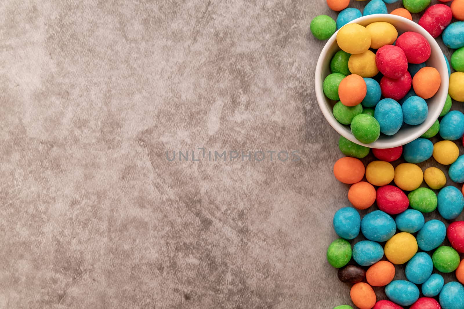 colorful candies top view on dark background with copy space