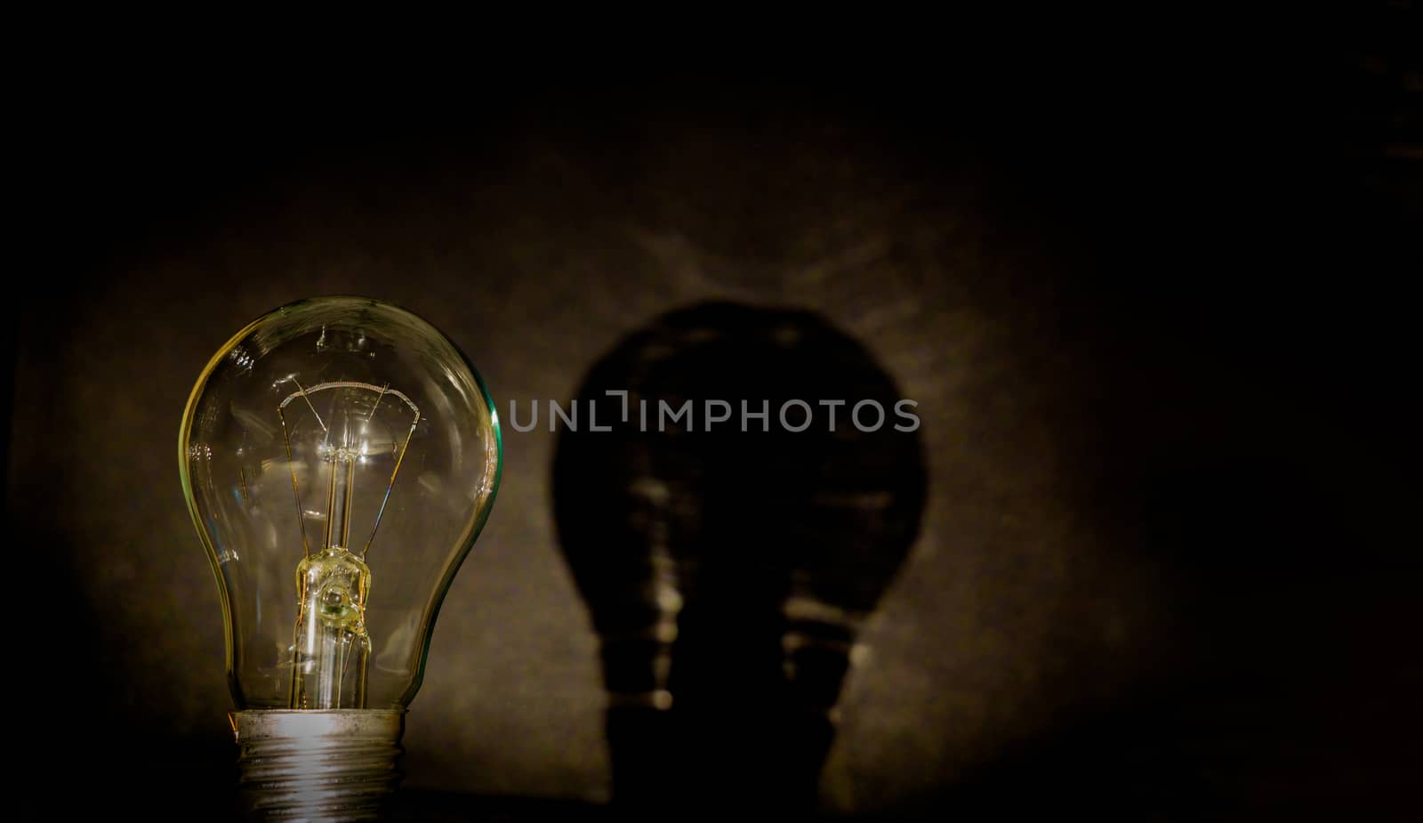 Light bulb, business idea concept. A light bulb on a black background to place text or illustration. The light bulb is a symbol of ideas, innovations, and new thoughts. 220 volt
