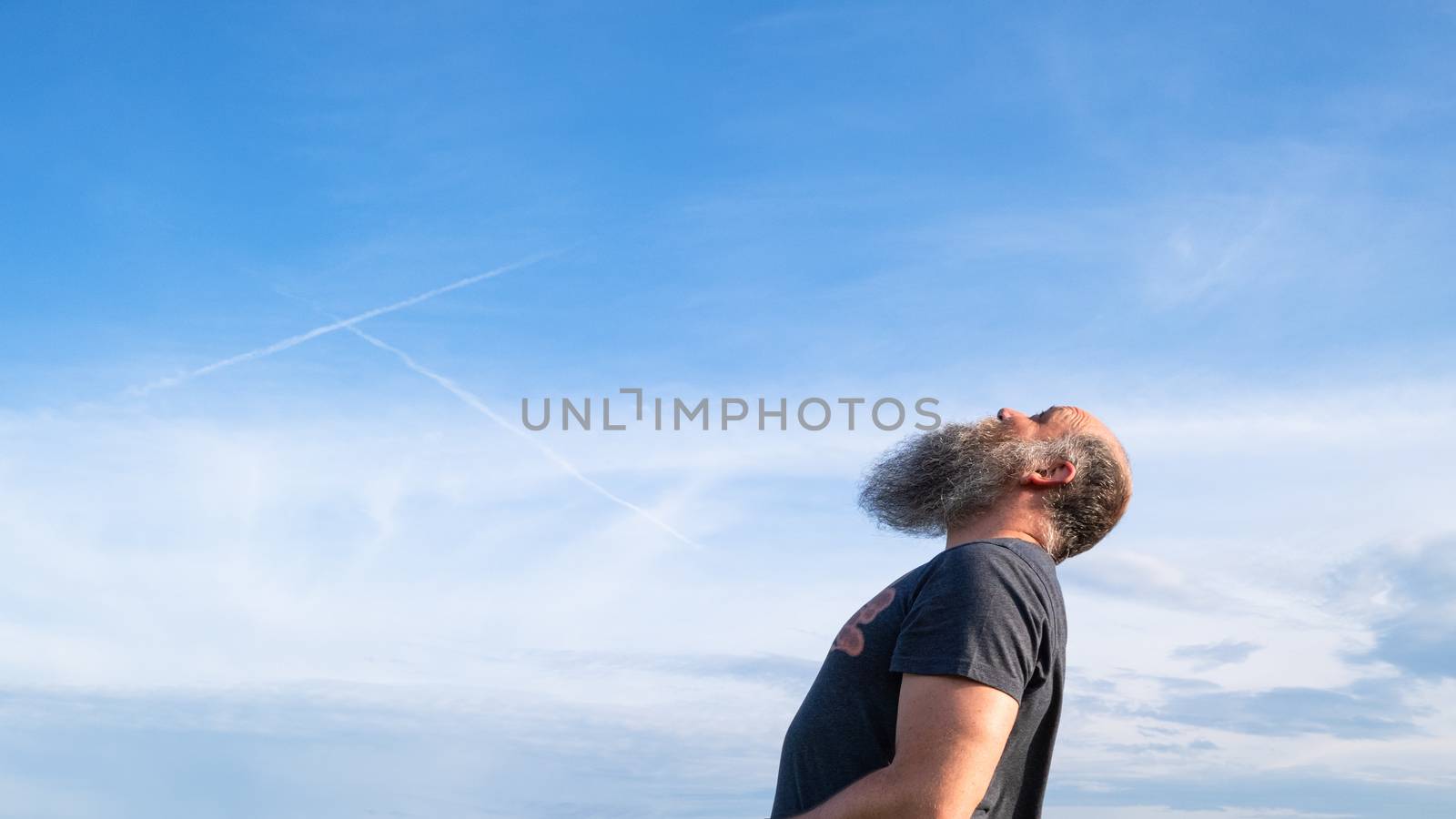 man looking up to the blue sky by magann