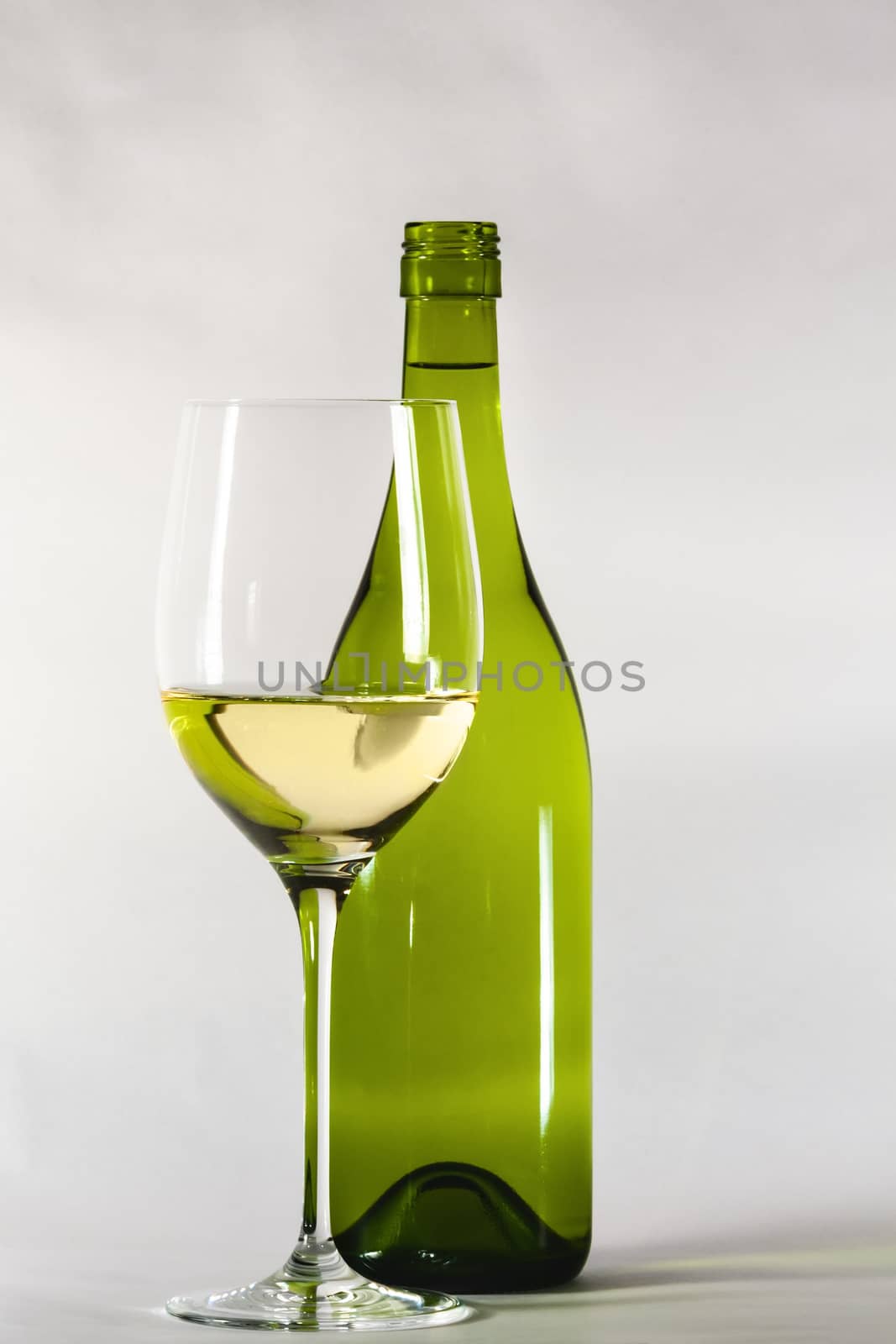 A vintage white wine bottle with a glass